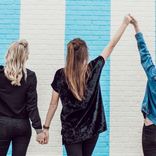 three women posing with their arms up